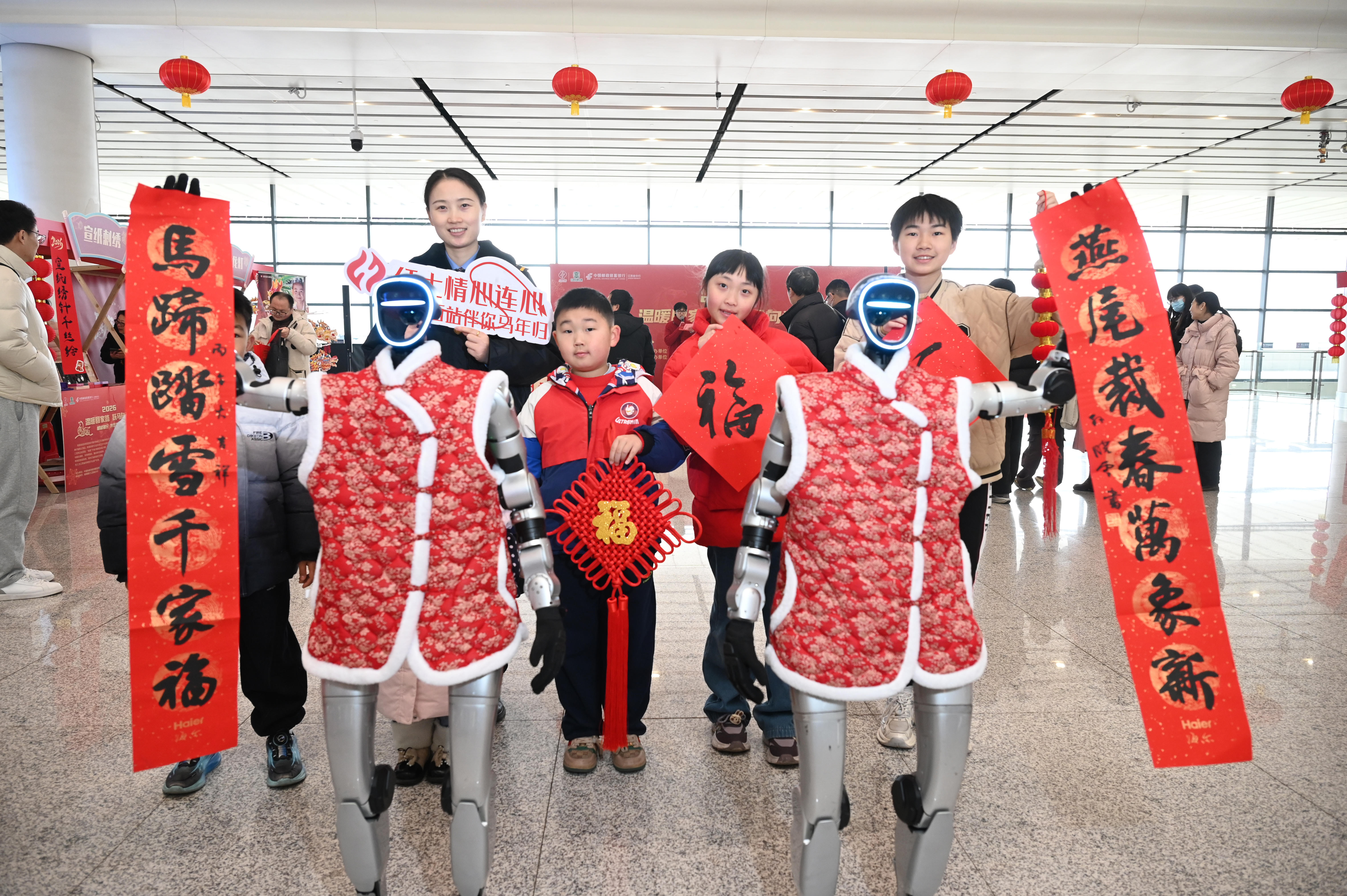 2026年2月10日,鐵路工作人員和旅客及機器人一起展示馬年春聯(lián)。鮑贛生 攝.jpg